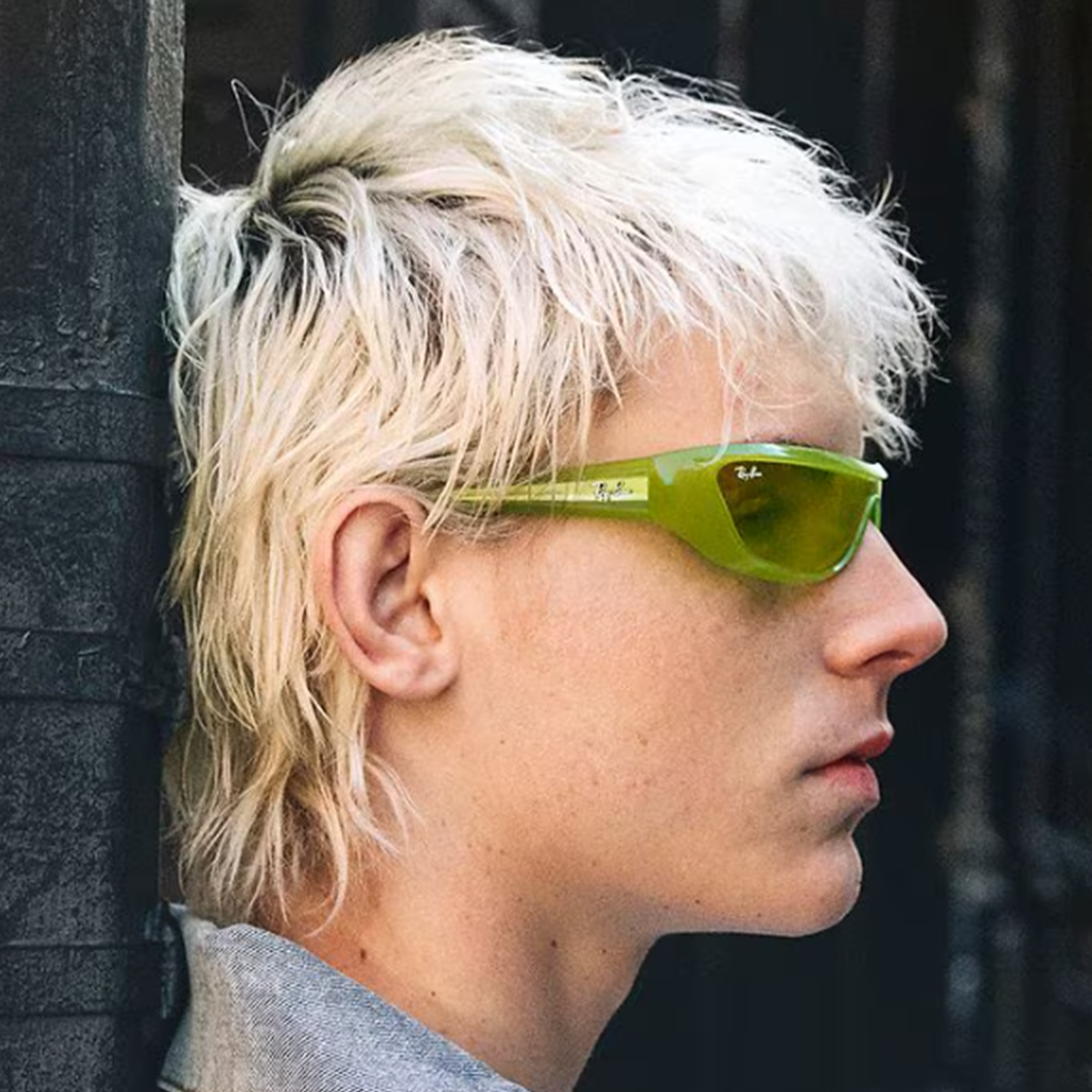 Homme avec des cheveux blonds portant des lunettes de soleil Ray-Ban vertes