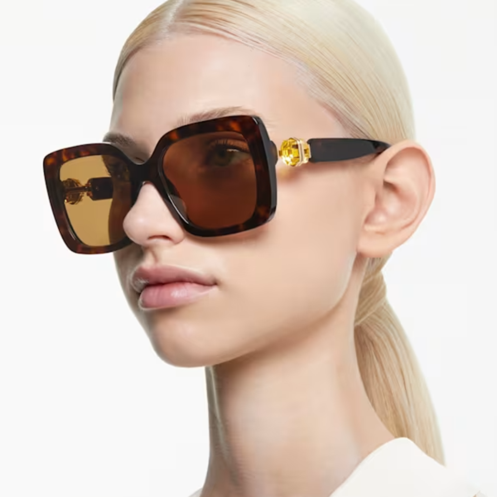 Femme portant des lunettes de soleil Swarovski avec une monture écaille de tortue