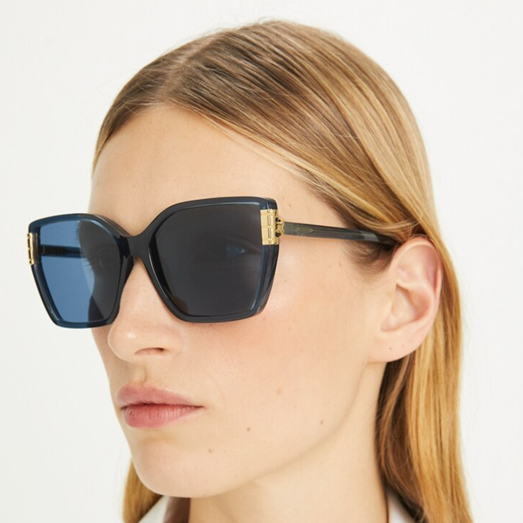 Femme portant des lunettes de soleil Tory Burch avec des verres noirs